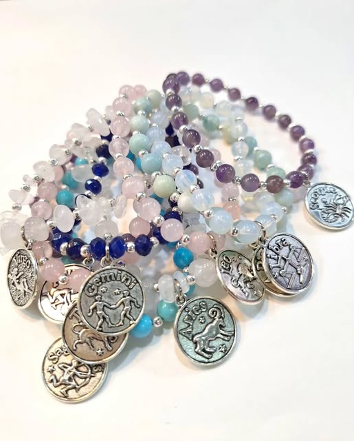 Pulseras de piedras en tonos pastel con dijes del zodíaco